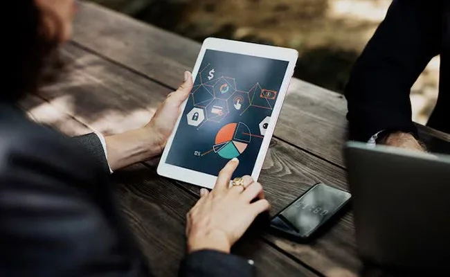  زنی در حال انجام طراحی گرافیکی و کارهای آماری روی آیپد/تبلت