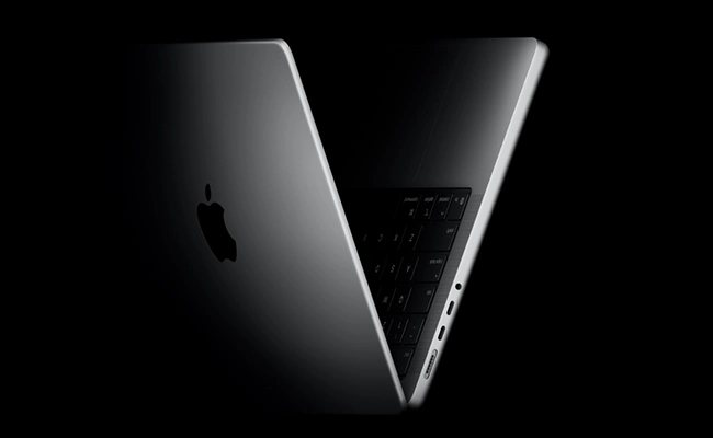 در این عکس یک لپ تاپ مک بوک اپل پرو در حالت نیمه باز نمایش داده شده است.