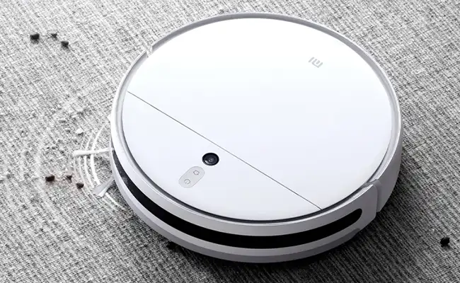 تصویر جاروی رباتیک در حال جمع کردن آشغال سطح فرش