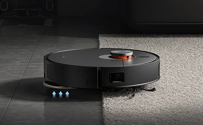 در این عکس یک جارو رباتیک ایکس ۲۰ مکس شیائومی در حال بالا رفتن از لبه&zwnj;ی فرش نمایش داده شده است.