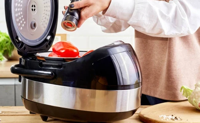 دختری در حال آماده&zwnj;سازی سبزیجات در مولتی&zwnj;کوکر مدرن